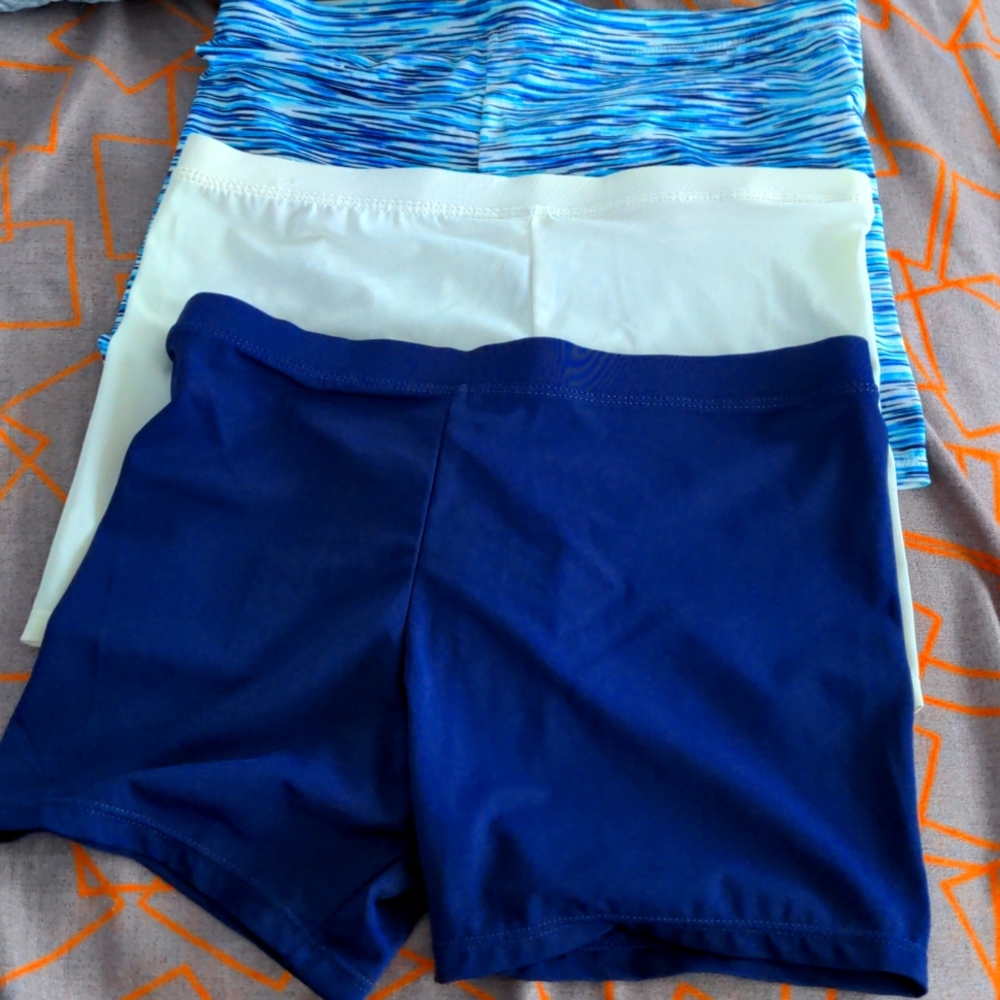 Three swim shorts (blue, white, and patterned)